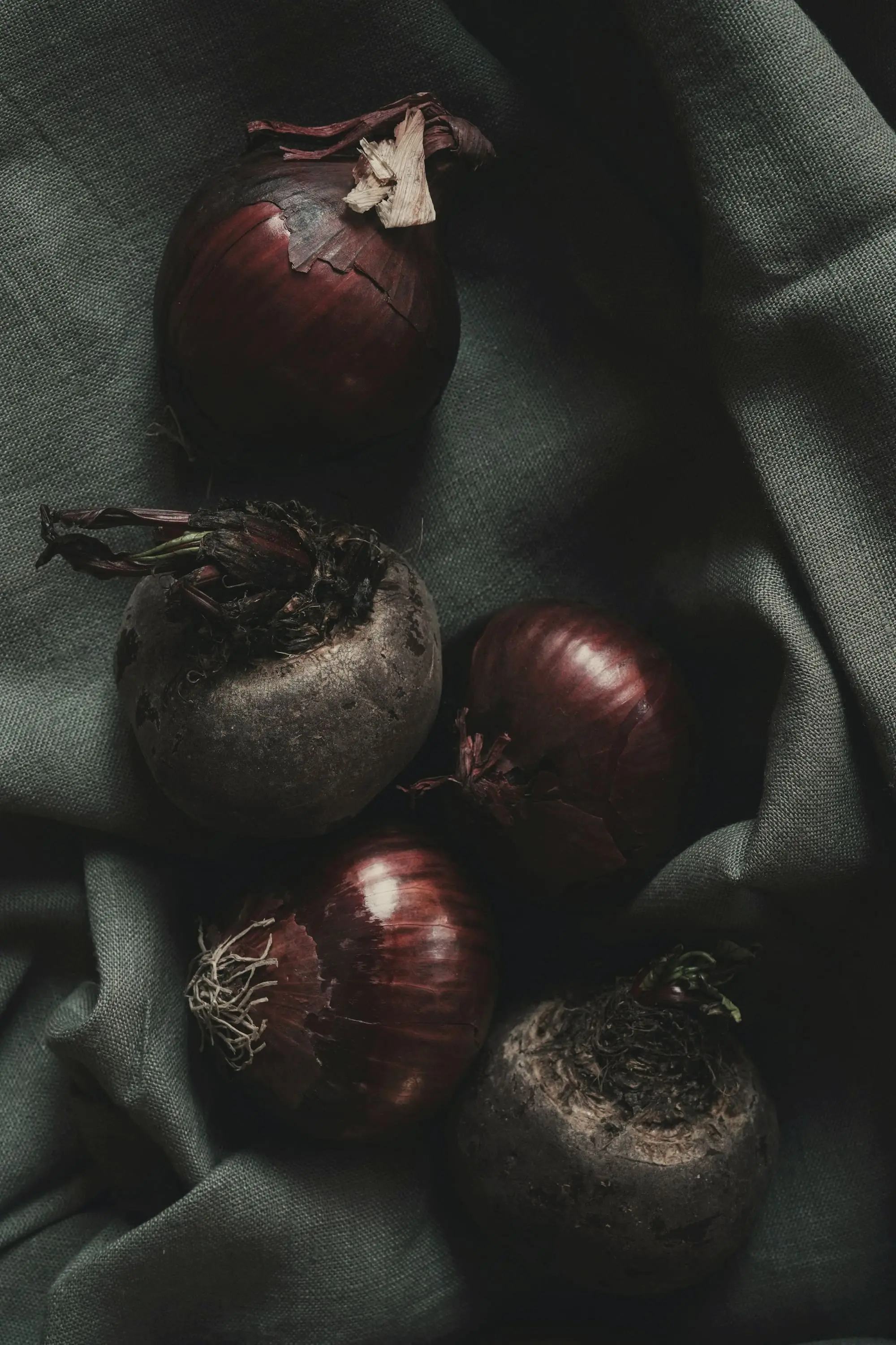 Beetroot and red onions resting on green-grey linen